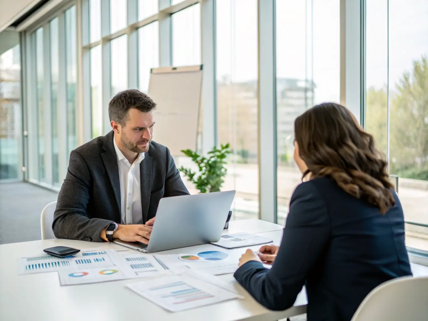 A consultant working with a client, reviewing a productivity plan on a tablet in a modern office setting, emphasizing collaboration and personalized strategies.